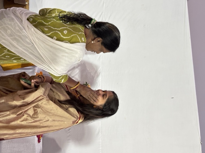 Siddhali Anup Shah assisting a woman during an indoor community visit