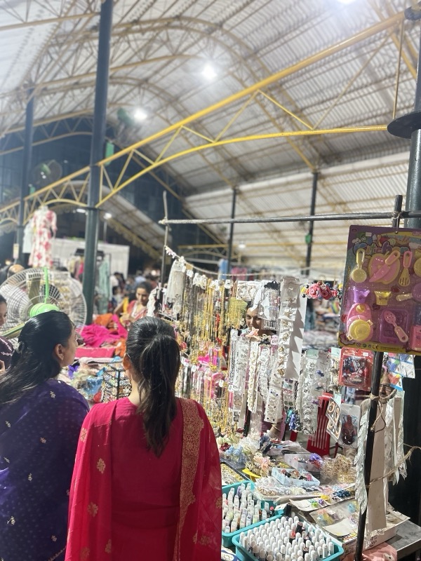 A visitor walking through stalls at a women-led market