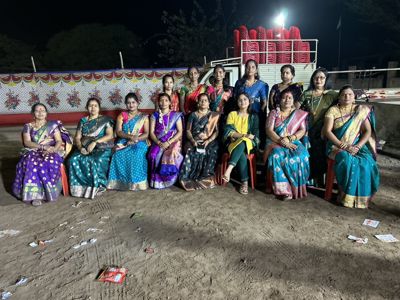 Women seated together at an evening community gathering
