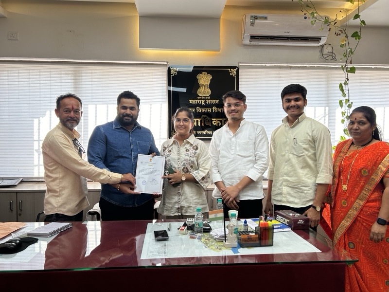 Siddhali Anup Shah receiving a document during an official meeting