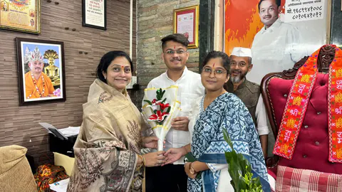 Siddhali Anup Shah presenting flowers during an office visit